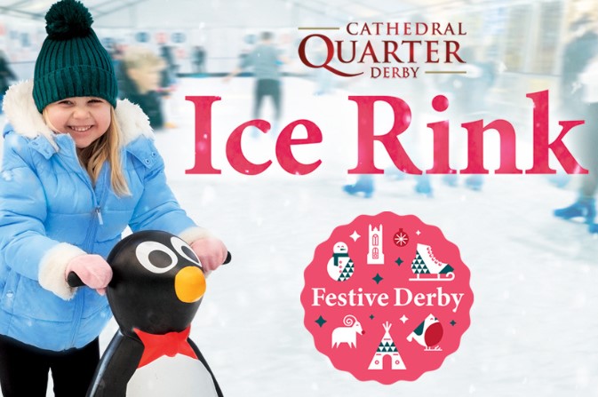 a smiling child holding a penguin skate aid on the ice rink